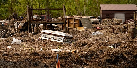 A displaced casket that floated from a cemetery during flooding from Hurricane Ida, sits among displaced marsh grass and ruin, in Ironton. (Photo | AP)