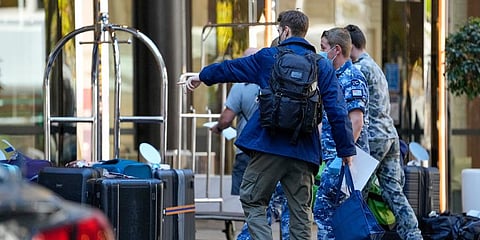 A traveler points to his luggage as he arrives at a quarantine hotel in Sydney, Australia. (Photo | AP)