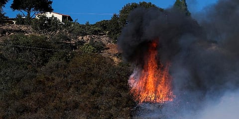 A wildfire burns near a home in Goleta, California. (Photo | AP)
