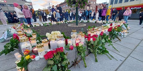 People gather around flowers and candles after a man killed several people on Wednesday afternoon, in Kongsberg, Norway, Thursday, Oct. 14, 2021. (Photo | AP)