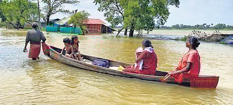 Priya, a resident of Poovam, along with her children, moves to a safer place through the flooded Alappuzha -Changanassery Road on Monday. Repeated warnings by government departments have caused panic