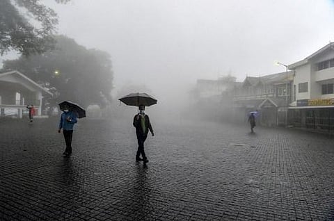 People cross an empty square at the Chowrasta Mall amidst heavy fog in Darjeeling. (Photo | AFP)