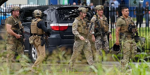 Members of the Houston Police SWAT team walk down the road outside YES Prep Southwest Secondary school after a shooting in Houston. (Photo | AP)