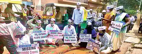 Citizens, along with AAP members, protest against the bad condition of roads  by performing puja to huge potholes on various streets on Wednesday