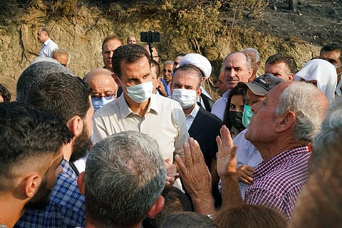 Syrian President Bashar Assad, wearing a mask to help prevent the spread of the coronavirus, speaks with people during his tour of areas that suffered heavy damage from deadly wildfires (Photo | AP)