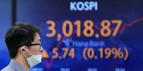 A currency trader walks near a screen showing the Korea Composite Stock Price Index (KOSPI) at a foreign exchange dealing room in Seoul, South Korea, Thursday, Oct. 21, 2021. (Photo | AP)