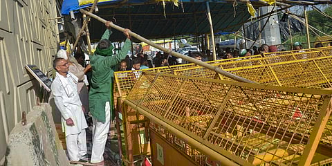 Farmers remove barricades from a road leading to Delhi near Ghazipur border picket site after SC orders. (File photo| PTI)