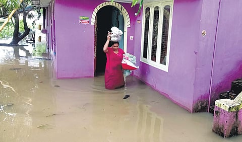 Anitha, a native of Arattukadavu in Vellayani, shifts household items to the terrace of her house which was flooded in heavy rain (Photo | Vincent Pulickal)