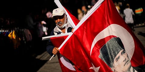 A vendor sells Turkish flags with the portrait of Mustafa Kemal Ataturk, founder of the modern Turkey, in a street market at the Eminonu district in Istanbul, Turkey, Oct. 21, 2021. (Photo | AP)