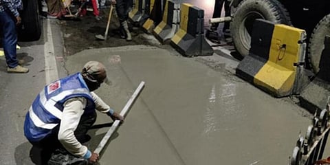 A GHMC official lays a table drain on a road in Hyderabad