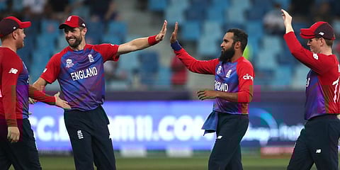 England's Adil Rashid is congratulated by teammates after taking the wicket of West Indies' Obed McCoy during the T20 World Cup match at the Dubai International Cricket Stadium. (Photo | AP)
