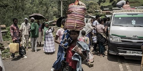 A girl carries her belongings on her head as she is leaving the city following a huge battle going on between Ethiopian Forces and Tigray People's Liberation Front fighters, Sep 16, 2021 (Photo | AFP)