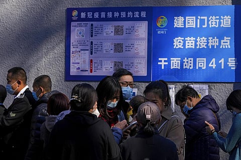Residents line up to receive booster shots against COVID-19 at a vaccination center in Beijing. (Photo | AP)