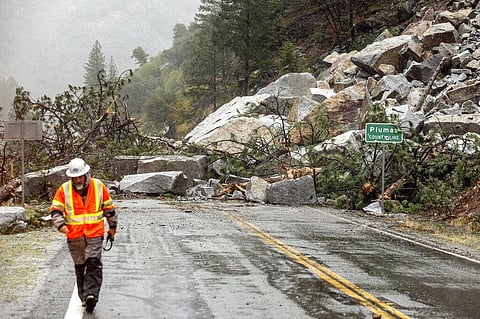 Caltrans maintenance supervisor Matt Martin walks by a landslide covering Highway 70 in the Dixie Fire zone on Sunday, Oct. 24, 2021, in Plumas County, California. (Photo | AP)
