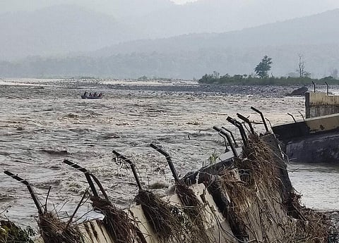 A rescue team delivers rations and essential supplies to Chukum village across the flooded Kosi river, with the broken retaining wall of the Lemon Tree hotel seen in Uttarakhand. (Photo | AP)