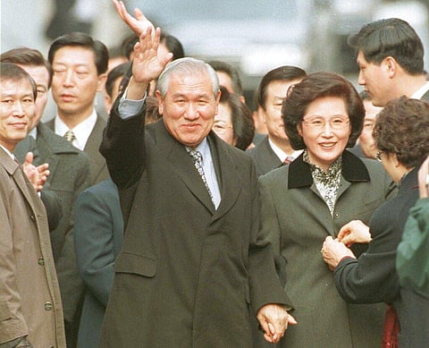 In this Dec. 22, 1997, file photo former South Korean President Roh Tae-woo, with his wife Kim Ok-sook standing beside him, waves to his supporters. (File Photo | AP)