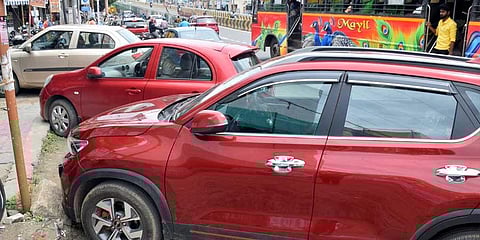 Cars parked on footpath leaving no room for pedestrians on 100-feet road in Coimbatore. (Photo |U Rakesh Kumar)