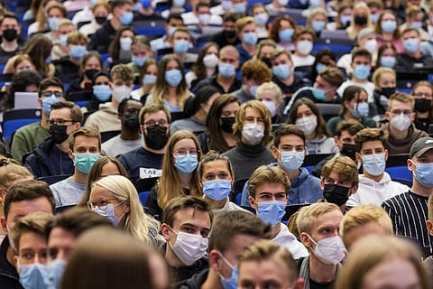 Students wear mouth-to-nose coverings while sitting close to each other during the lecture 'BWL 1' in lecture hall H1 of the Westfaelische Wilhelms-Universitaet in Muenster, Germany. (Photo | AP)