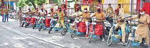 Postmen and postwomen astride their e-bikes outside the JP Nagar  sub post office in Bengaluru | Express