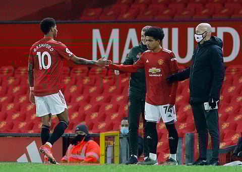 Manchester United's Marcus Rashford (L) walks out as substitute Shola Shoretire (R-red shirt) is ready to make his debut. (Photo | Twitter/@MarcusRashford)