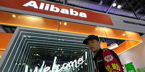 A security guard passes by the Alibaba booth at a trade show in Beijing, China. (Photo | AP)