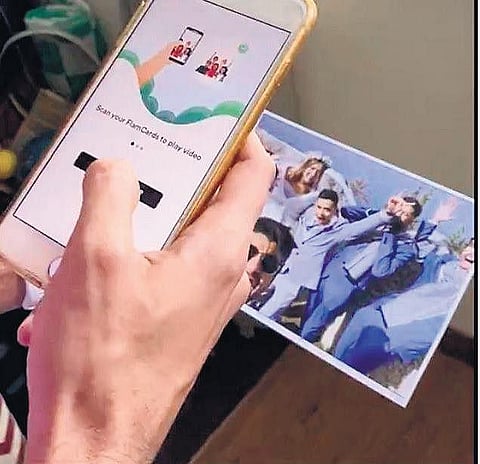 . Just like you scan a QR code and it takes you to a website where you can order food in a restaurant, the app allows you to watch a video with a photograph.