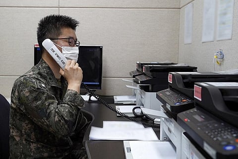 An unidentified South Korean military officer makes a test call with a North Korean officer through an inter-Koran military communication line. (Photo | AP)