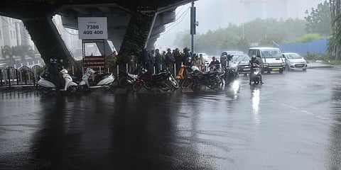 Commuters taking shelter under the flyover to protect themselves from sudden rain in Madhapur. (Photo| Vinay Kumar Madapu, EPS)
