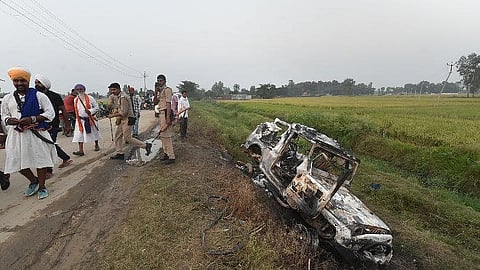 People take a look at the overturned SUV, which was destroyed in the violence.