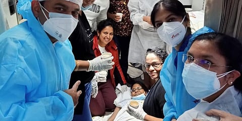 Passengers and medical staff onboard who helped deliver the baby safely pose with the mother on AI 150. (Photo | Twitter, Air India)