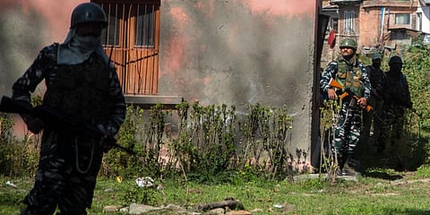 Paramilitary soldiers guard during the funeral of prominent pharmacist Makhan Lal Bindroo in Srinagar on Wednesday. (Photo | AP)