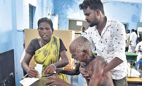 An elderly man being helped to cast his vote at a polling booth | P JAWAHAR