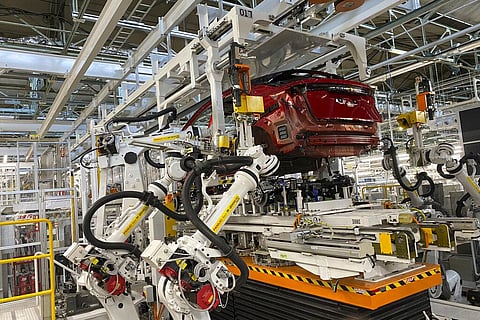 Robotic arms put in the electric vehicle powertrain into the Ariya model in the assembly line at Nissan's Tochigi plant in Kaminokawa town, Tochigi prefecture, Japan. (Photo | AP)