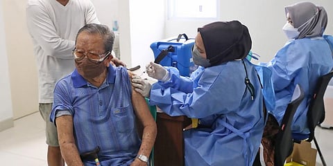 An elderly man receives a shot of the COVID-19 vaccine during a vaccination campaign at a community health center in Tangerang on the outskirts of Jakarta, Indonesia. (Photo | AP)