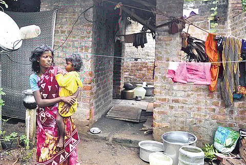 A tribal woman with her child standing in front of her half-constructed house at Thizukuzangundram in Chengalpet  district | DEBADATTA MALLICK