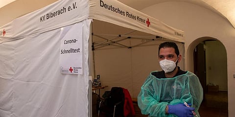 Red Cross worker Motasen Edrees stands in front of a tent at City Hall where he performs Corona rapid tests in Biberach, Germany. (Photo | AP)