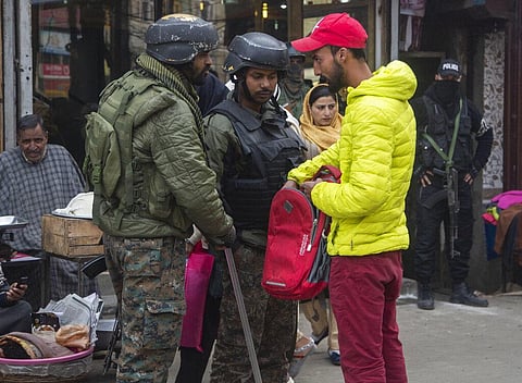 Indian paramilitary soldiers question a civilian during a surprise check operation in a busy market in Srinagar. (Photo | AP)