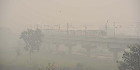 A Metro train makes its way amid low visibility due to a thick layer of smog, in New Delhi on Friday. (Photo | Shekhar Yadav/EPS)