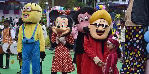 Children taking photos with cartoon character models during Balotsav as part of Children's Day celebrations at Thummalapalli Kalakshetream in Vijayawada. (Photo| P Ravindra Babu, EPS)