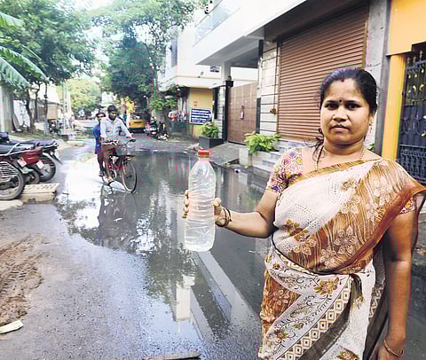 A woman holds a bottle of Metro Water mixed with sewage coming out of taps at Jawahar Street at Kodungaiyur in Chennai on Sunday |  DEBADATTA MALLICK