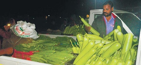 A farmer sells vegetables at Vantimamidi vegetable market in Hyderabad