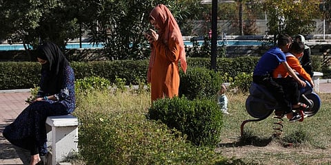 Afghan women look at their cell phones as children play at a coastline tourist resort of Golem, 50 kilometers (30 miles) west of Tirana, Albania. (Photo | AP)