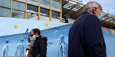 Pedestrians wearing face masks to protect against coronavirus, pass in front of a metro station in Athens, Greece. (Photo | AP)