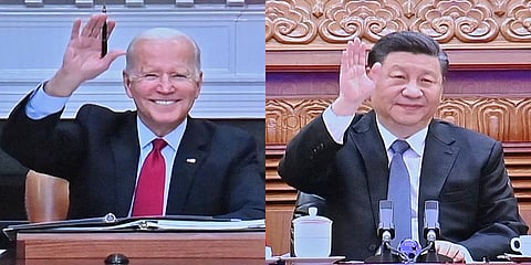 Chinese President Xi Jinping (R) and U.S. President Joe Biden appear on a screen as they hold a meeting via video link, in Beijing. (Photo | AP)