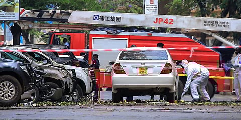 Security forces and forensics officers examine the scene of a blast on a street near the parliamentary building in Kampala, Uganda. (Photo | AP)