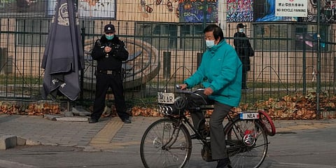 FILE - A resident on bicycle past by security personnel outside the U.S. Embassy in Beijing, China on Nov. 16, 2021. (Photo | AP)
