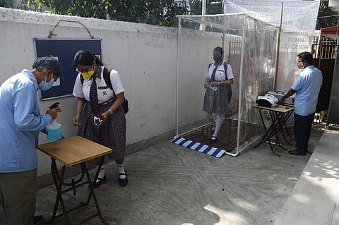 Students walk through a sanitization tunnel at the entrance of a school on the day schools partially reopened after they were closed due to the coronavirus pandemic in Kolkata. (Photo | AP)