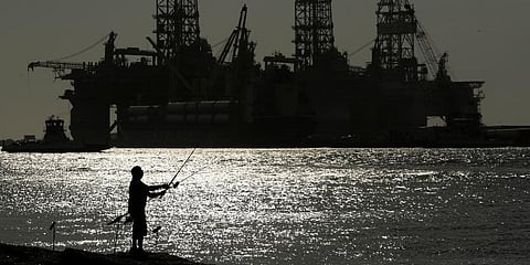 A man wears a face mark as he fishes near docked oil drilling platforms, Friday, May 8, 2020, in Port Aransas, Texas. (File Photo | AP)