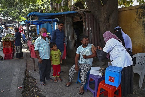 A health worker inoculates a man against the coronavirus on a pavement in Hyderabad. (Photo | AP)