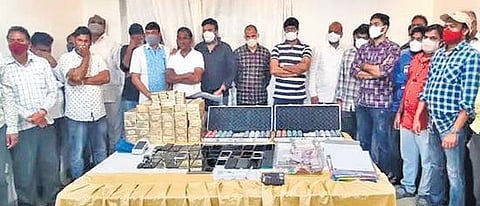 Thirty persons, including former Mahabubabad MLA Sriram Bhadraiah, arrested by the police, stand with the seized items at the farmhouse in Manchirevula